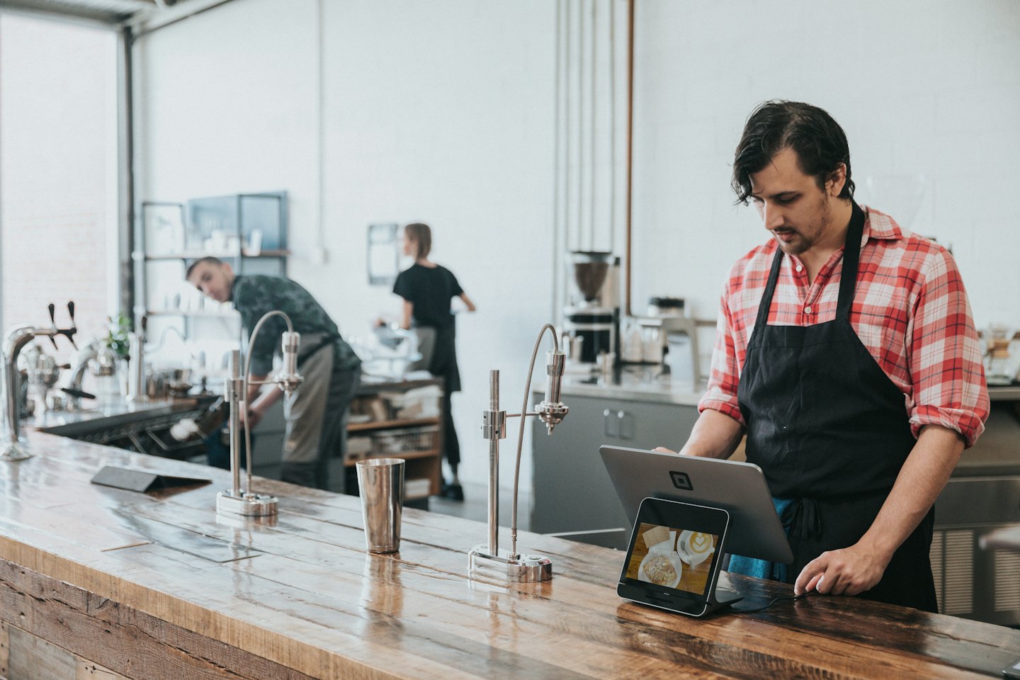 Un barista toma un pedido en el sistema TPV de una cafetería.